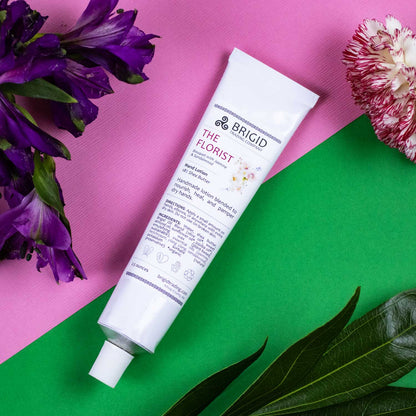 Natural hand lotion tube, white with purple logo; angled view for size