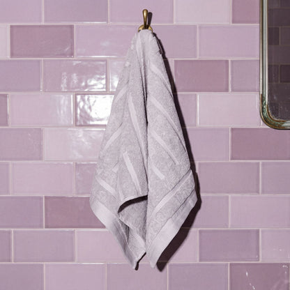 Lilac cotton hand towel hanging with stitched edge