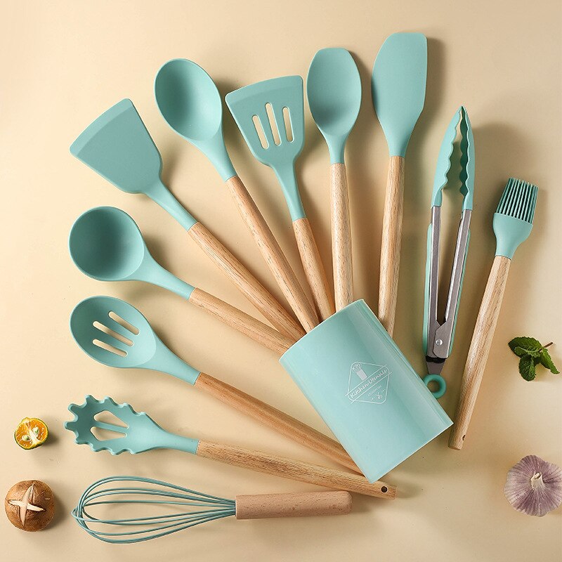 Teal silicone cooking utensils with wooden handles, including spatula, spoon, and fork tools