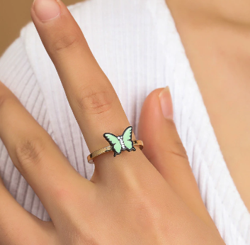 Gold fidget spinner ring with green butterfly charm on finger