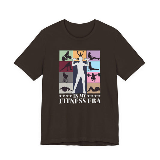 Brown strength T-shirt with colorful fitness collage graphic and “IN MY FITNESS ERA” text