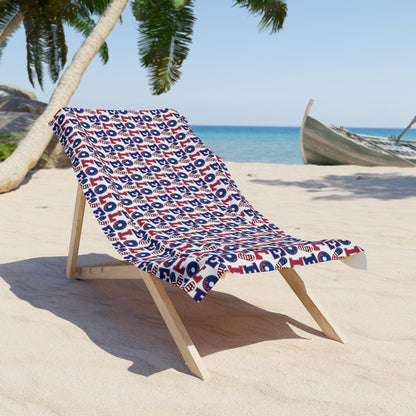 Beach towel with blue and white LOL pattern draped over a wooden lounge chair