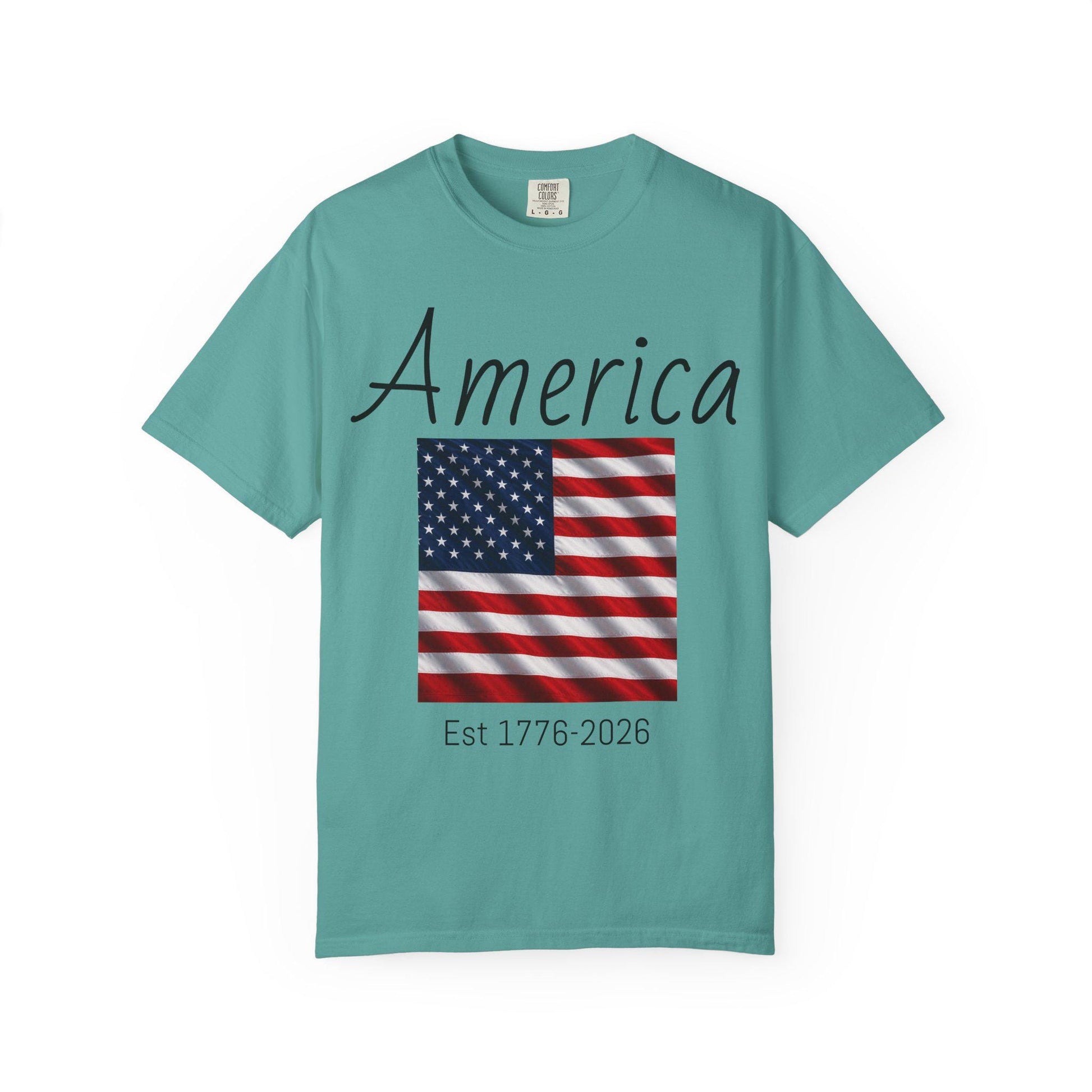 Teal T-shirt with “America” script, USA flag graphic, and “Est 1776-2026” text
