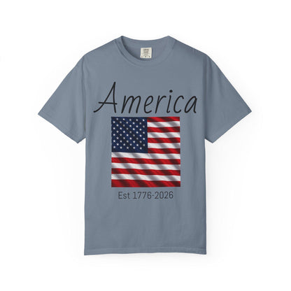Slate gray T-shirt with “America” script, USA flag graphic, and “Est 1776-2026” text