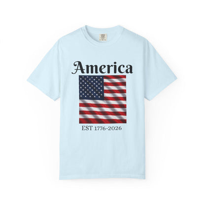 Light blue T-shirt with America text and American flag graphic, EST 1776-2026