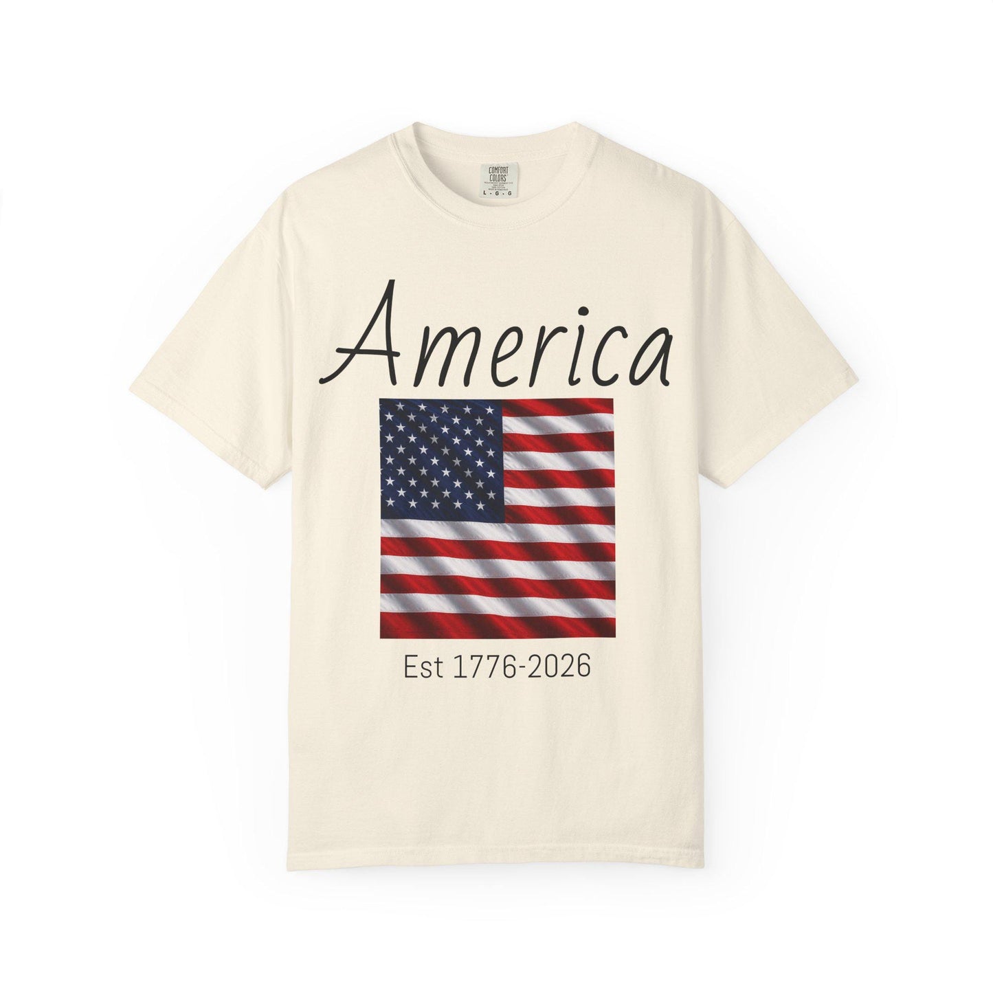 Ivory T-shirt with 'America' script, U.S. flag graphic, and 'Est 1776-2026'
