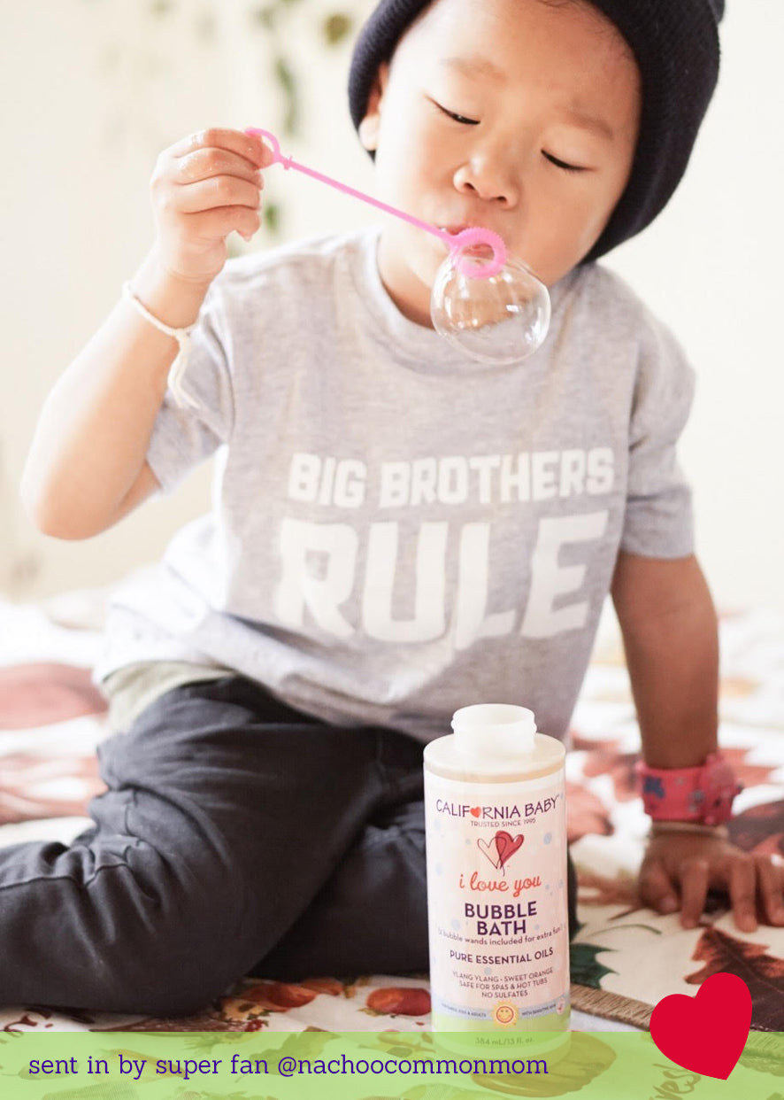 Bubble bath bottle on bed, pink liquid, California Baby label and cap