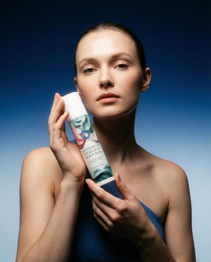 Watermelon hydration moisturizer tube held by hands, white and green cap