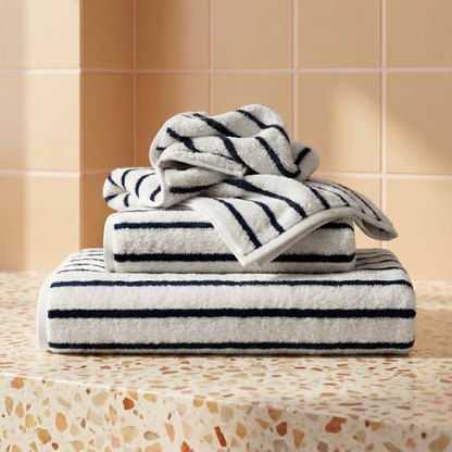 Plush cotton towels, white with navy stripes, folded with stripe borders