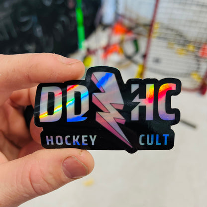 Hockey sticker held in hand with holographic multi-color letters and lightning