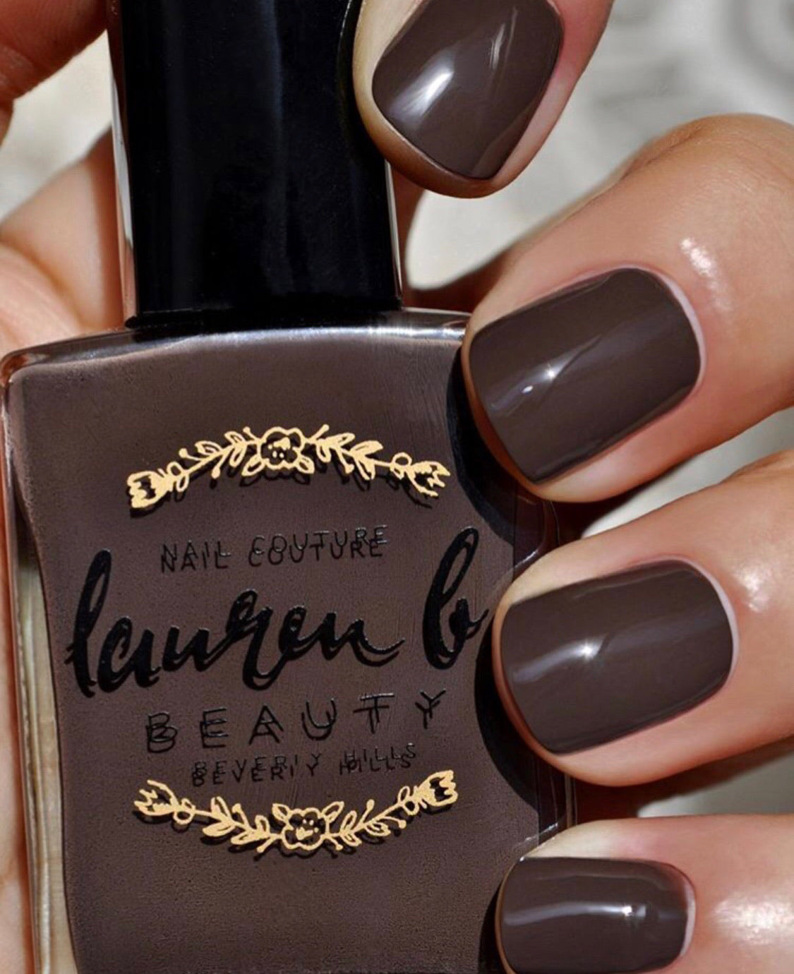 Brown nude nail polish on fingernails, glossy finish