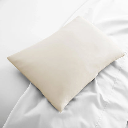 Ivory travel pillowcase, smooth fabric folded on bed