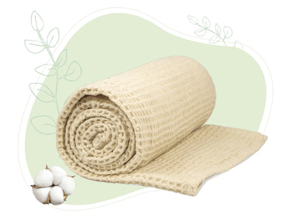 Ivory waffle weave throw blanket rolled, showing tight woven waffle texture.