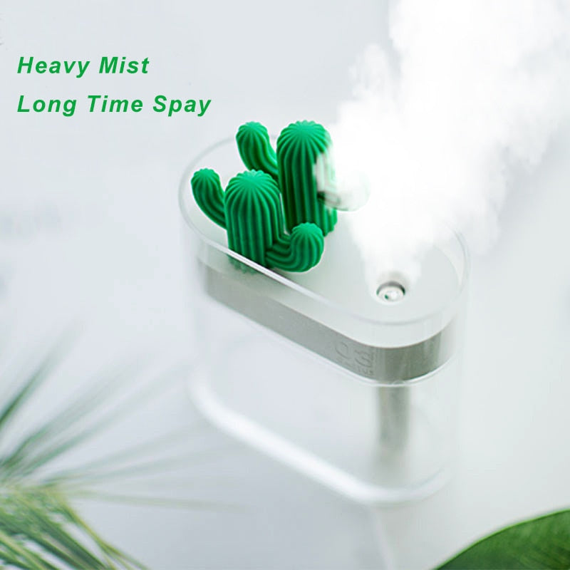 White ultrasonic humidifier with green cactus top, heavy mist rising from the nozzle