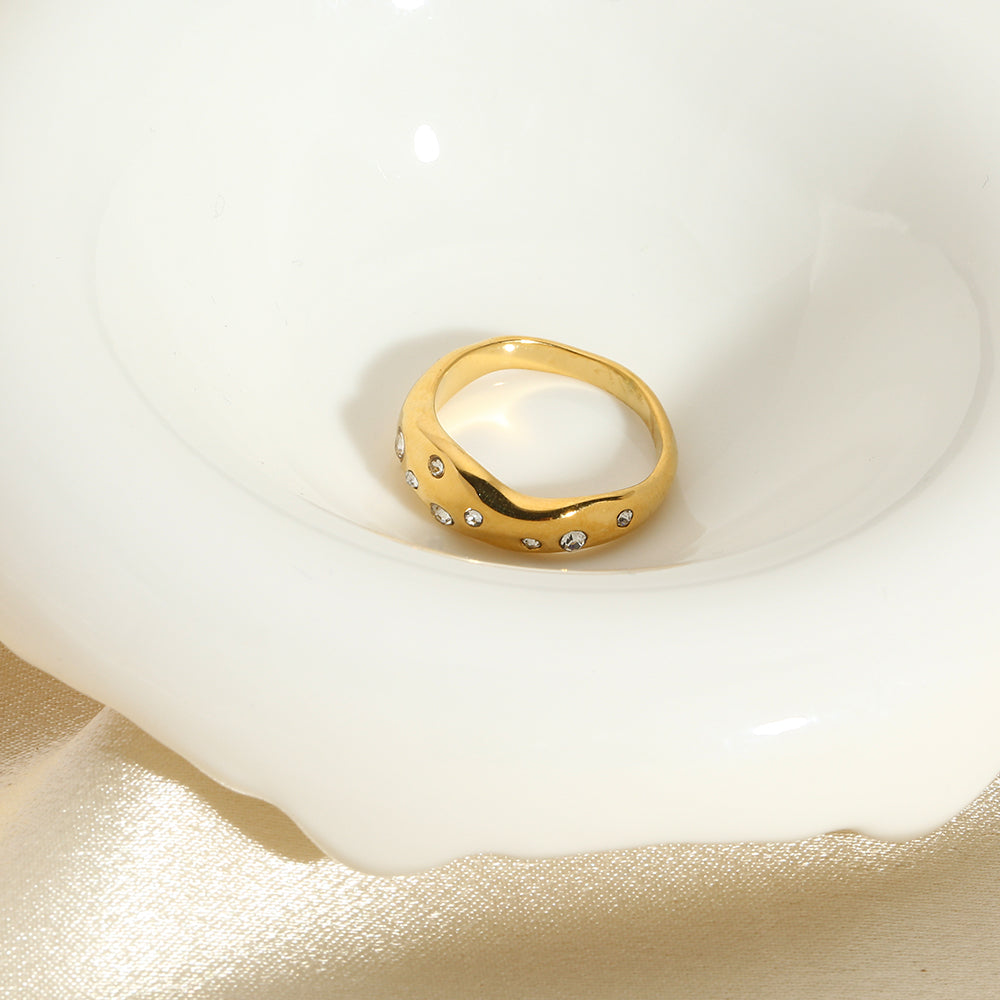 Gold snake-shape ring with clear stones, centered top view