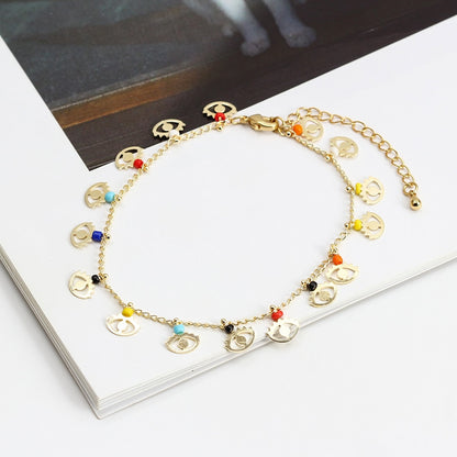 Gold-tone charm bracelet with colorful eye-and-heart charms and lobster clasp