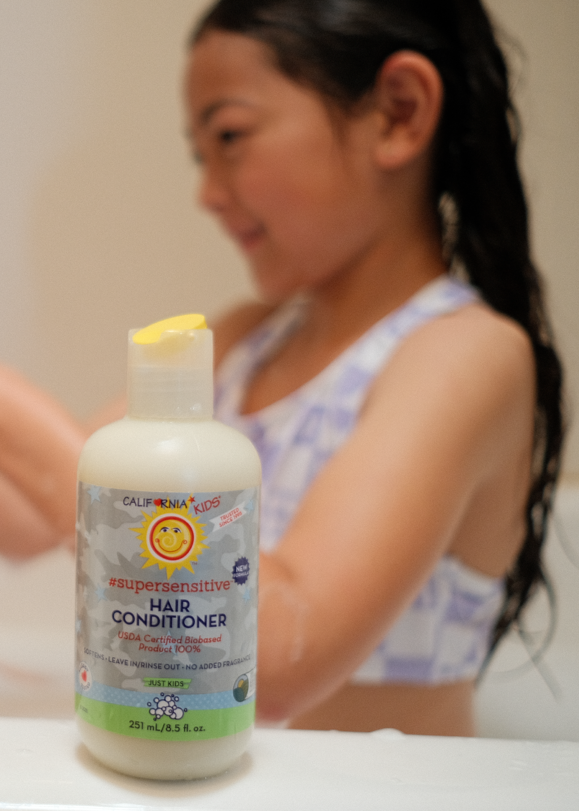 Kids supersensitive conditioner bottle with pump, pale cream liquid and white label