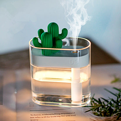 Glass ultrasonic humidifier with green cactus top and warm light, with a rising mist cloud