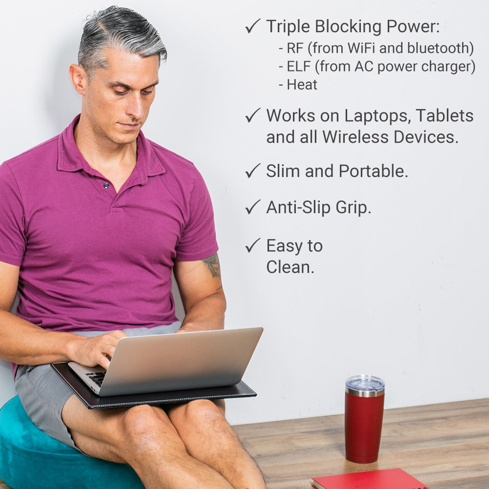 Black laptop pad with anti-slip grip, supporting a laptop on a person’s lap.