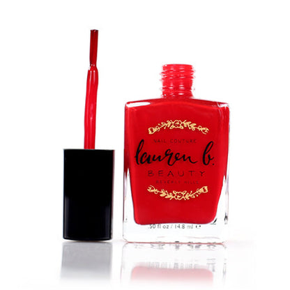 Rodeo Drive nail polish bottle with open cap, red nail polish.