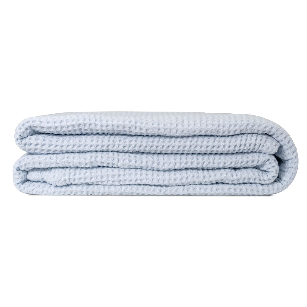 Light blue waffle weave throw blanket, folded in a compact stack.
