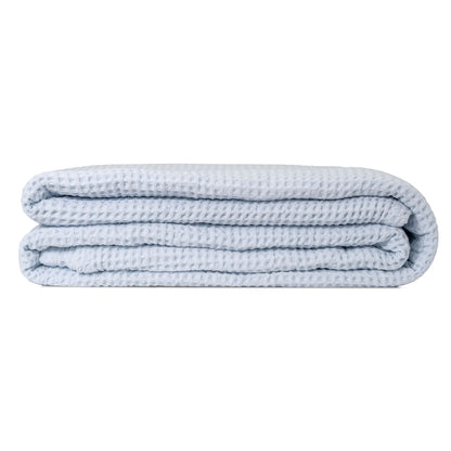 Light blue waffle weave throw blanket, folded in a compact stack.