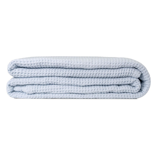 Light blue waffle weave throw blanket, folded in a compact stack.