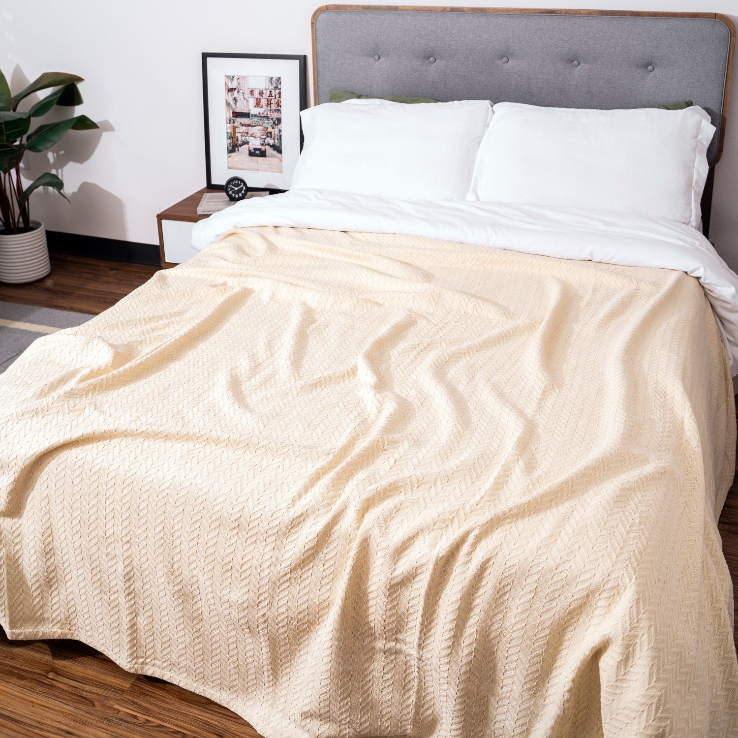 Herringbone cotton blanket, ivory, folded and laid across a bed with chevron pattern