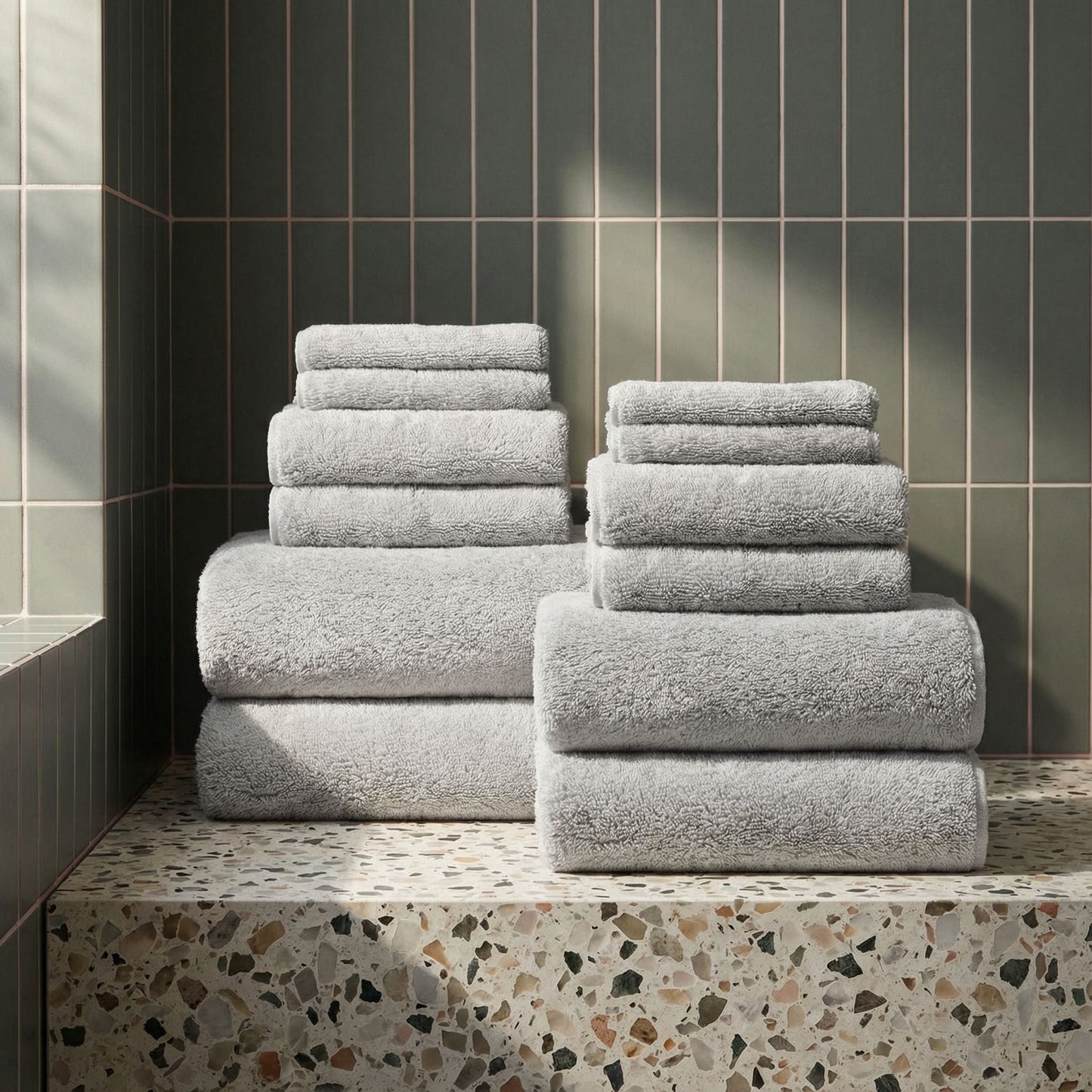White plush towel set stacked on a step, terry texture clearly visible
