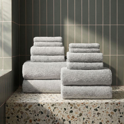 White plush towel set stacked on a step, terry texture clearly visible
