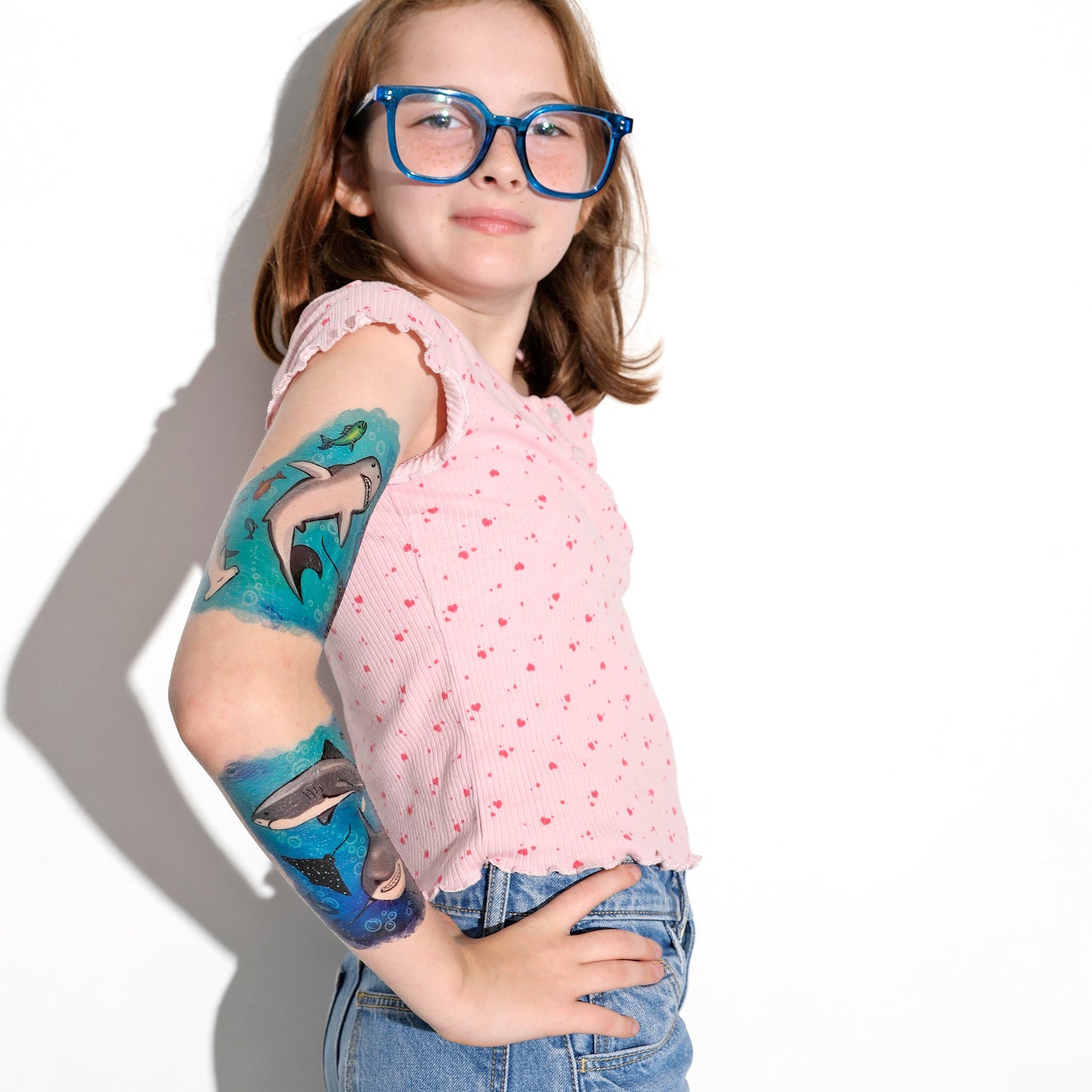 Temporary shark tattoo sleeve on a child’s arm with blue sea-creature graphics