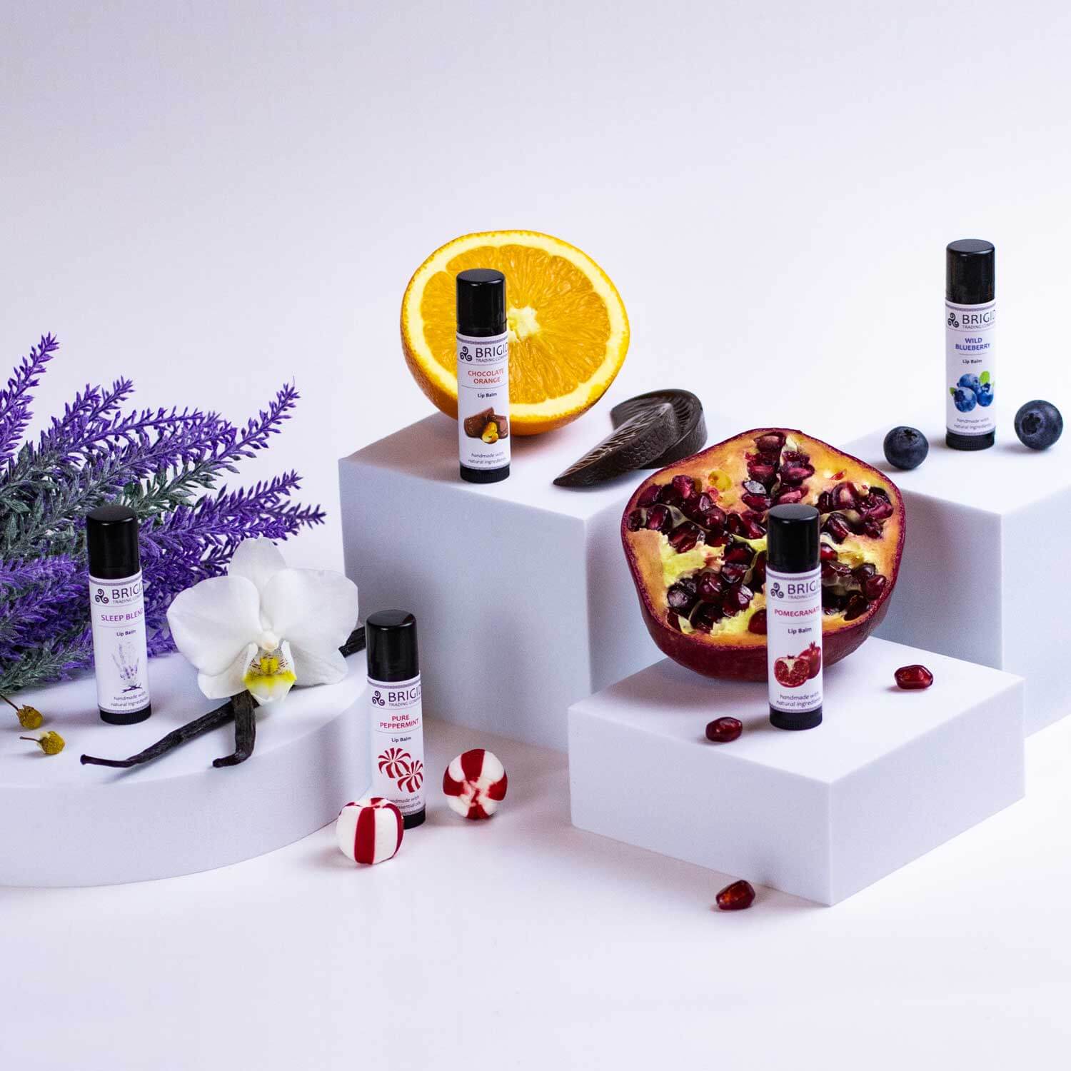 Blueberry natural lip balm set of tubes with black caps, shown on white blocks.