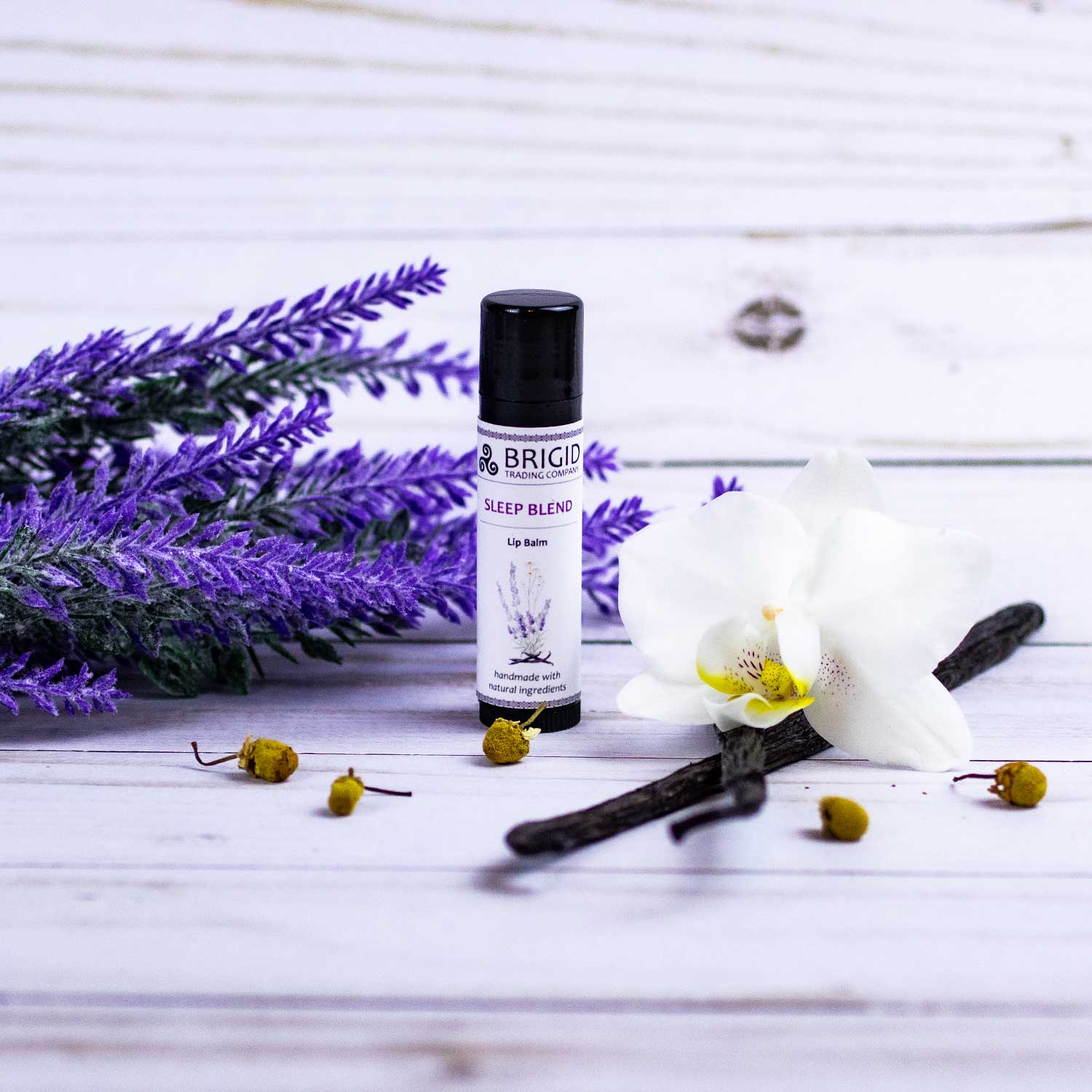 Sleep Blend lip balm tube with black cap beside lavender sprigs