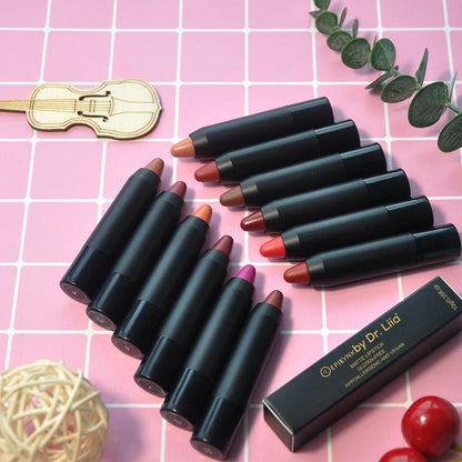 Set of lip crayon balm pencils in assorted shades on pink tile