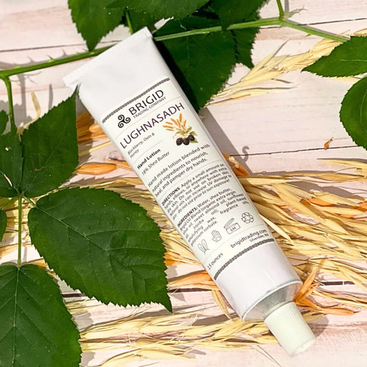 Natural hand lotion tube, white with BRIGID and LUGHNASADH branding, flip-top cap