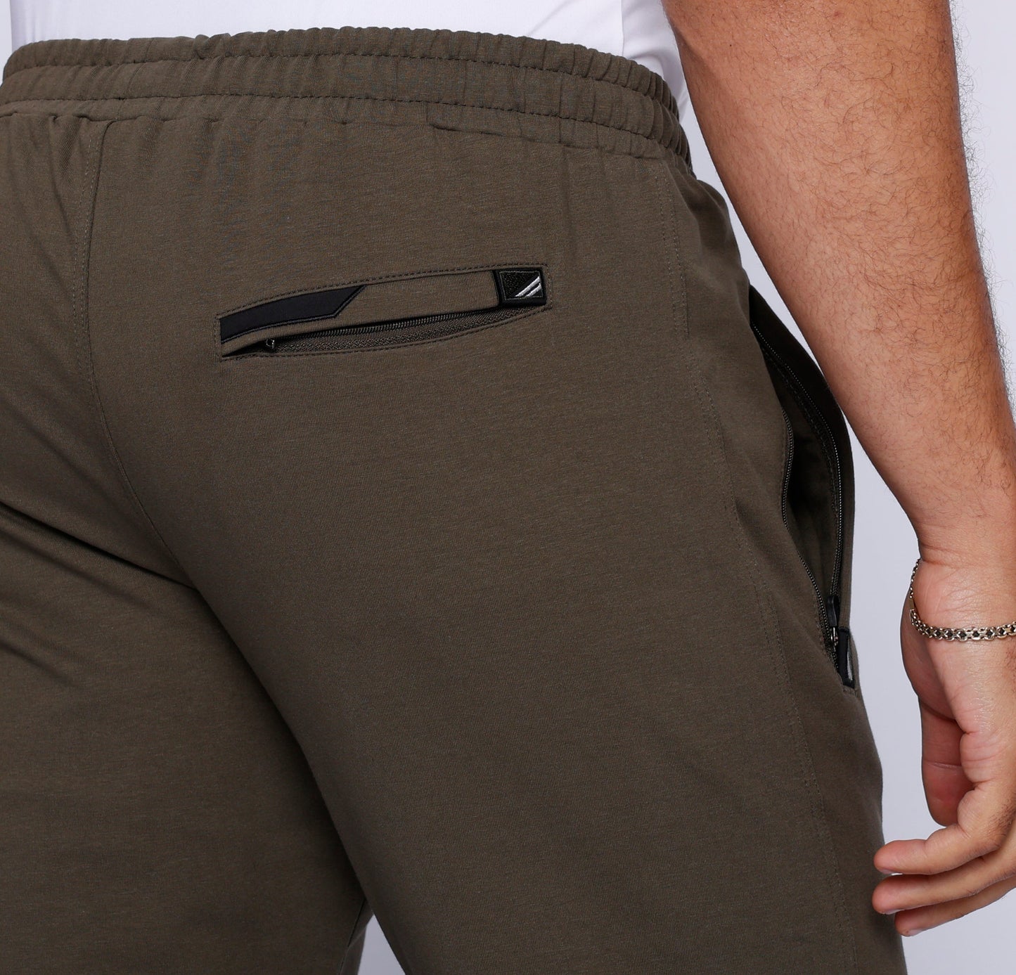 Khaki green straight sweatpants close-up: back elastic waistband and logo emblem