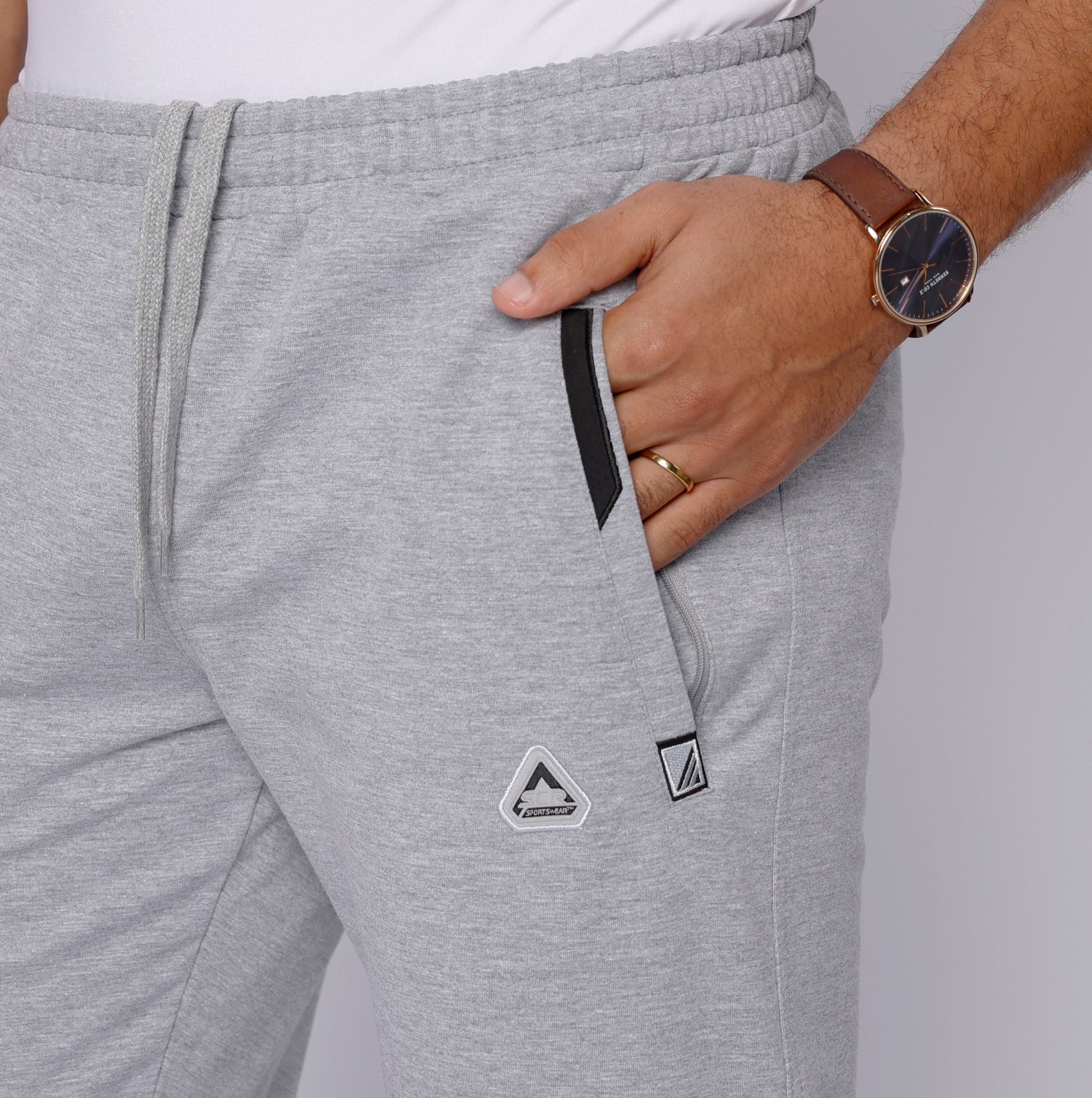 Light grey heather sweatpants close-up: elastic waist, drawstring, side logo patches