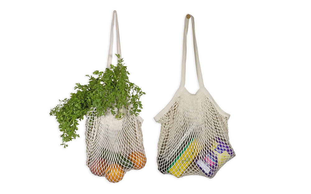 Mesh shopping bag with long handles, holding tomatoes and greens in white net