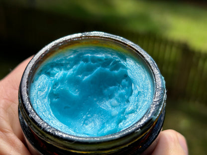 Methylene Blue tallow balm balm surface in open jar, teal-blue color