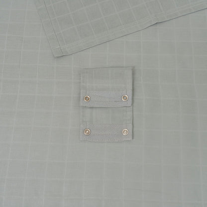 Muslin car seat cover in gray with snap-button pocket detail