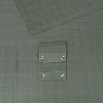 Green muslin car seat cover with snap-button fastening pocket panel detail