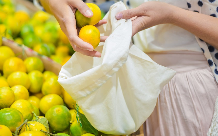 Muslin produce bag held open with lemons and limes inside