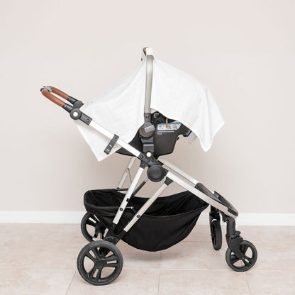 Muslin car seat cover in white, mounted on stroller with side drape