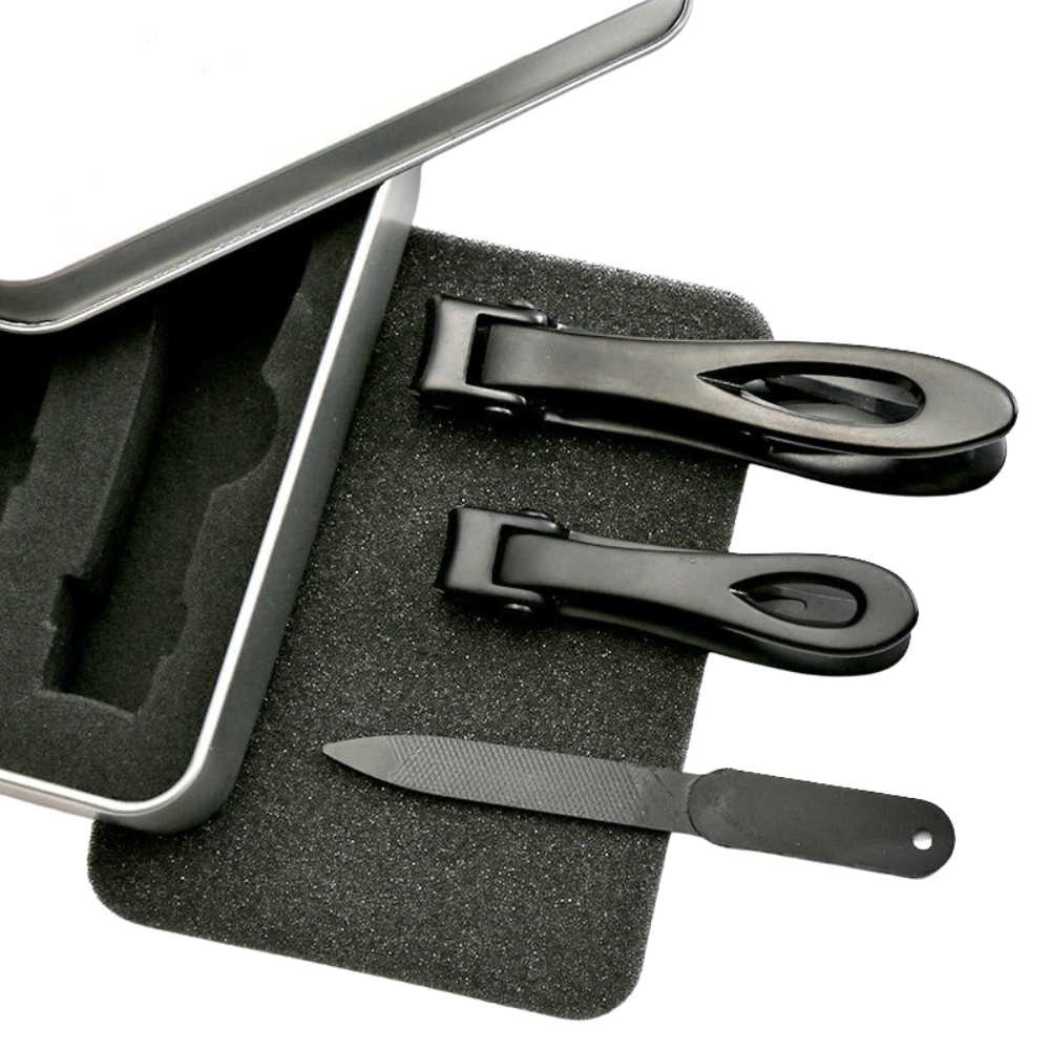 Nail clipper tools and emery file in black foam tray.