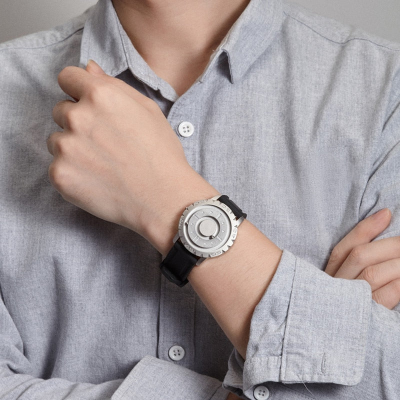Men’s magnetic pointer watch worn on wrist with black strap and silver-toned watch face