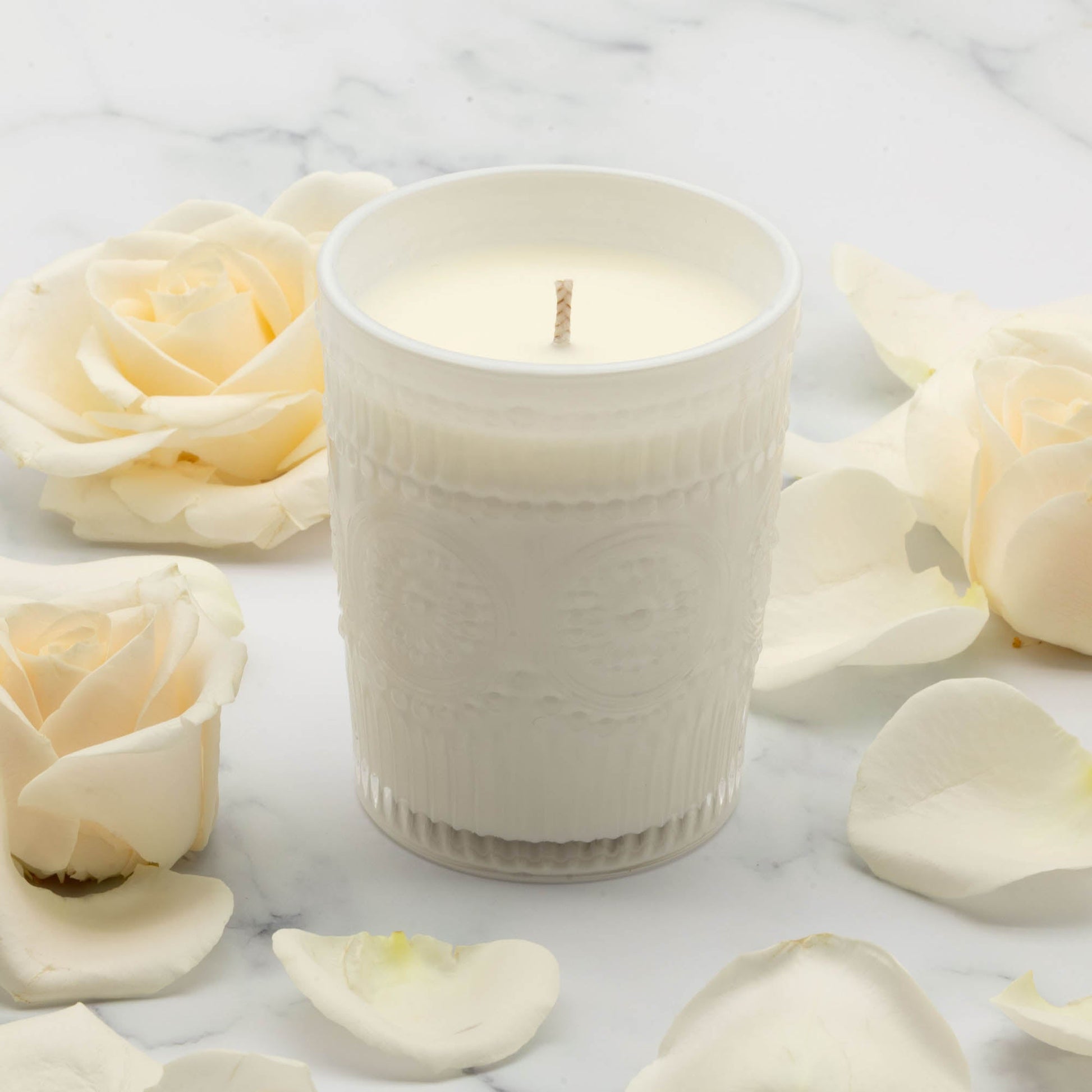 White glass scented candle with ribbed sides and centered wick