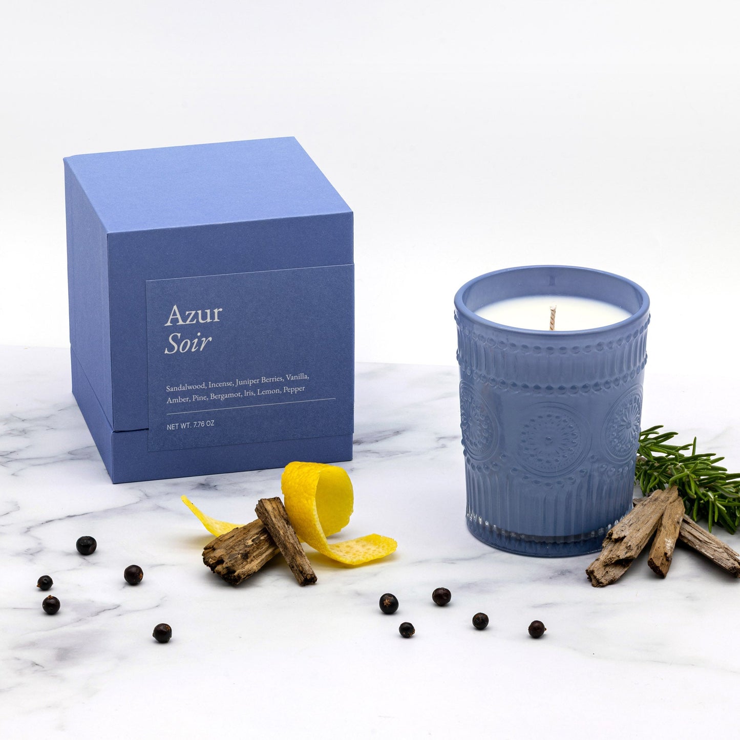 Scented glass candle with blue jar beside “Azur Soir” gift box