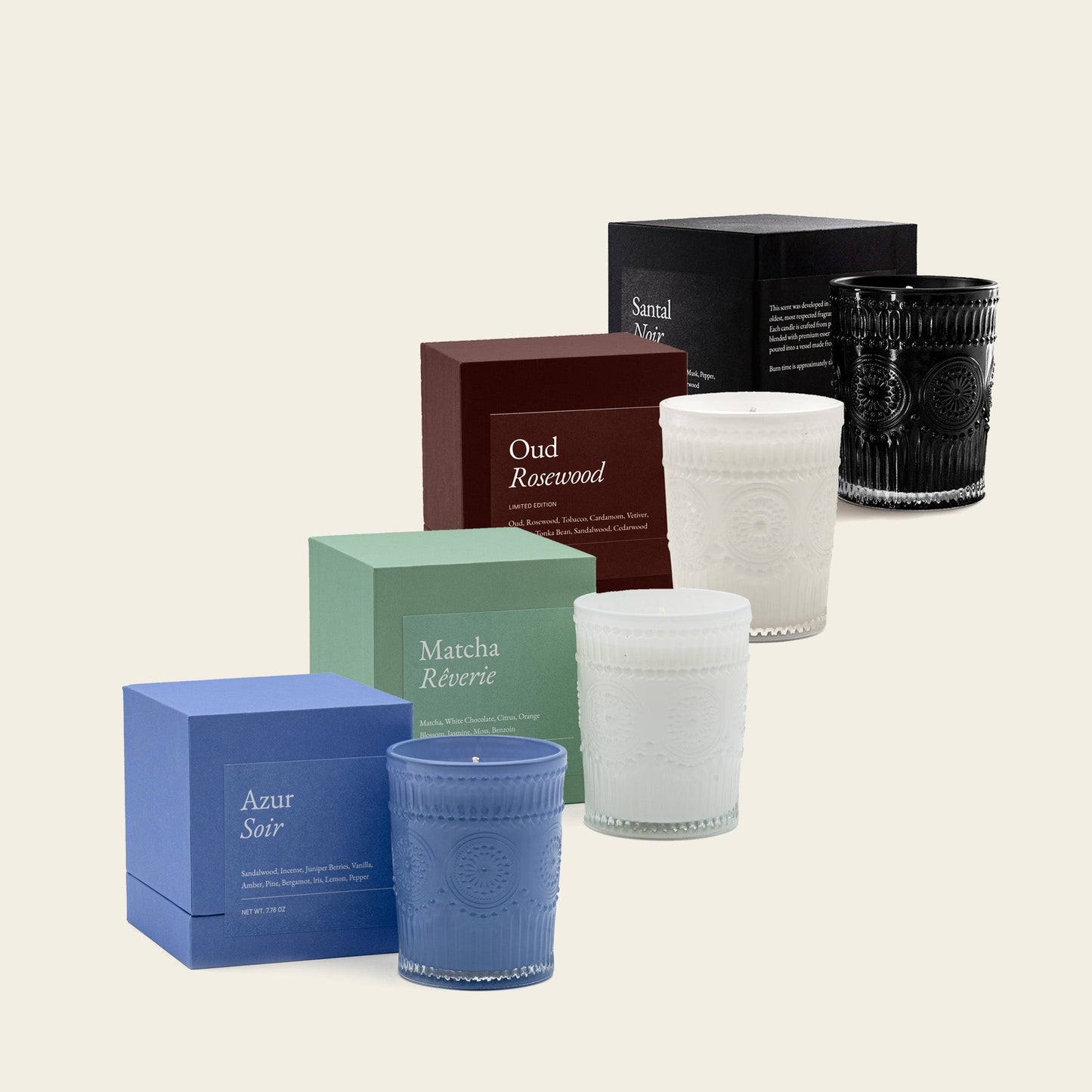 Assorted scented glass candles with gift boxes in blue, green, white, and dark tones
