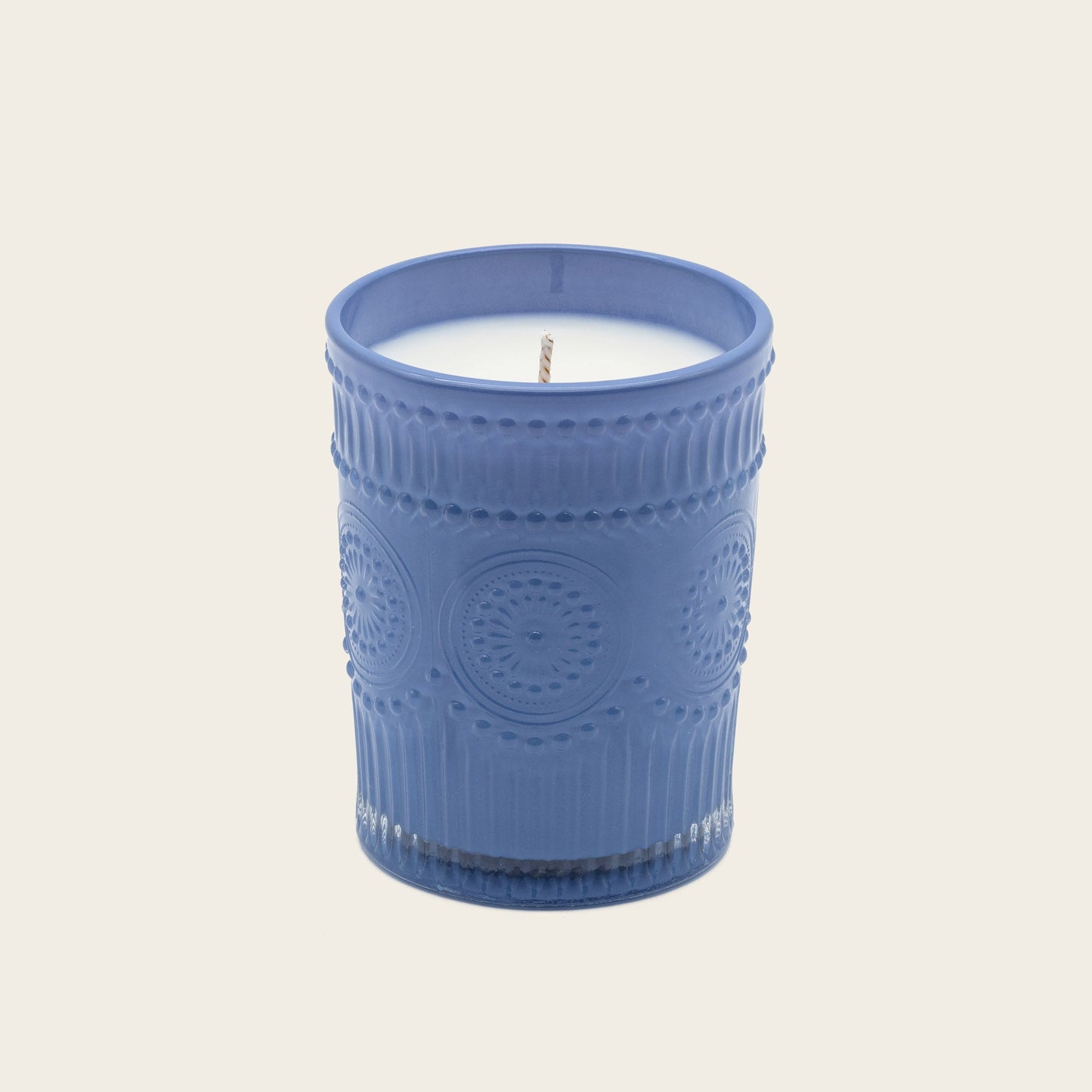Blue embossed glass scented candle, lit flame