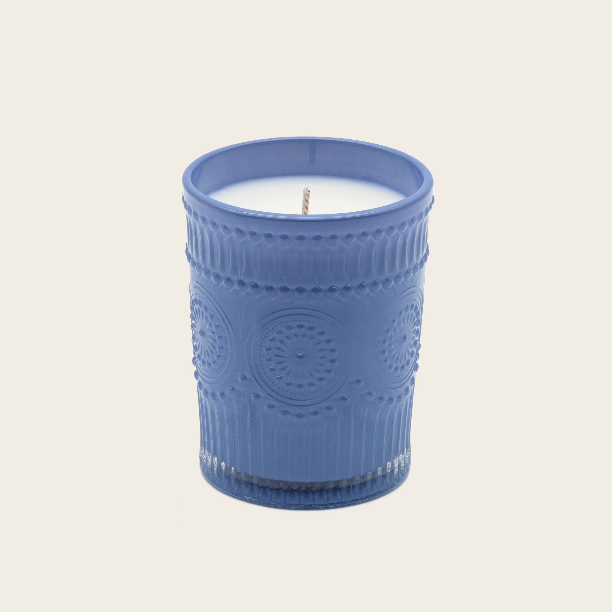 Blue embossed glass scented candle, lit flame